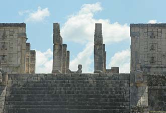 Chac-Mool au premier plan en haut de l'escalier du Temple des Guerriers avec les deux piliers serpentiformes